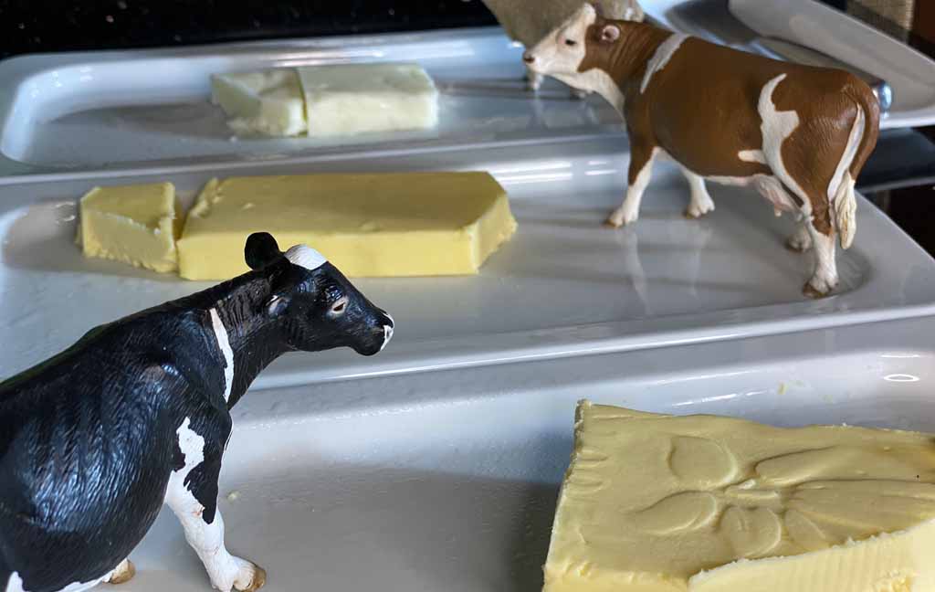 Butter neben dem eine Spielzeugfigur einer Kuh steht