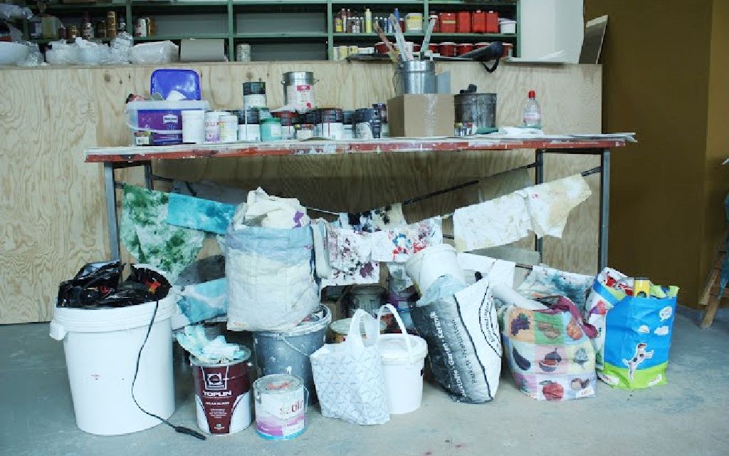 Arbeitstisch ist zugestellt mit unterschiedlichen Dingen