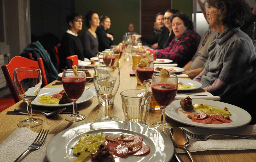 Menschen sitzen an einem gedeckten Tisch