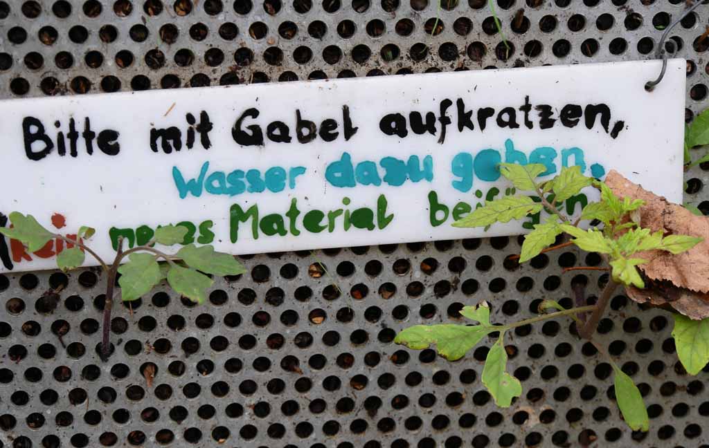 Schild "Bitte mit Gabel aufkratzen, Wasser dazu geben, kein neues Material beifügen"