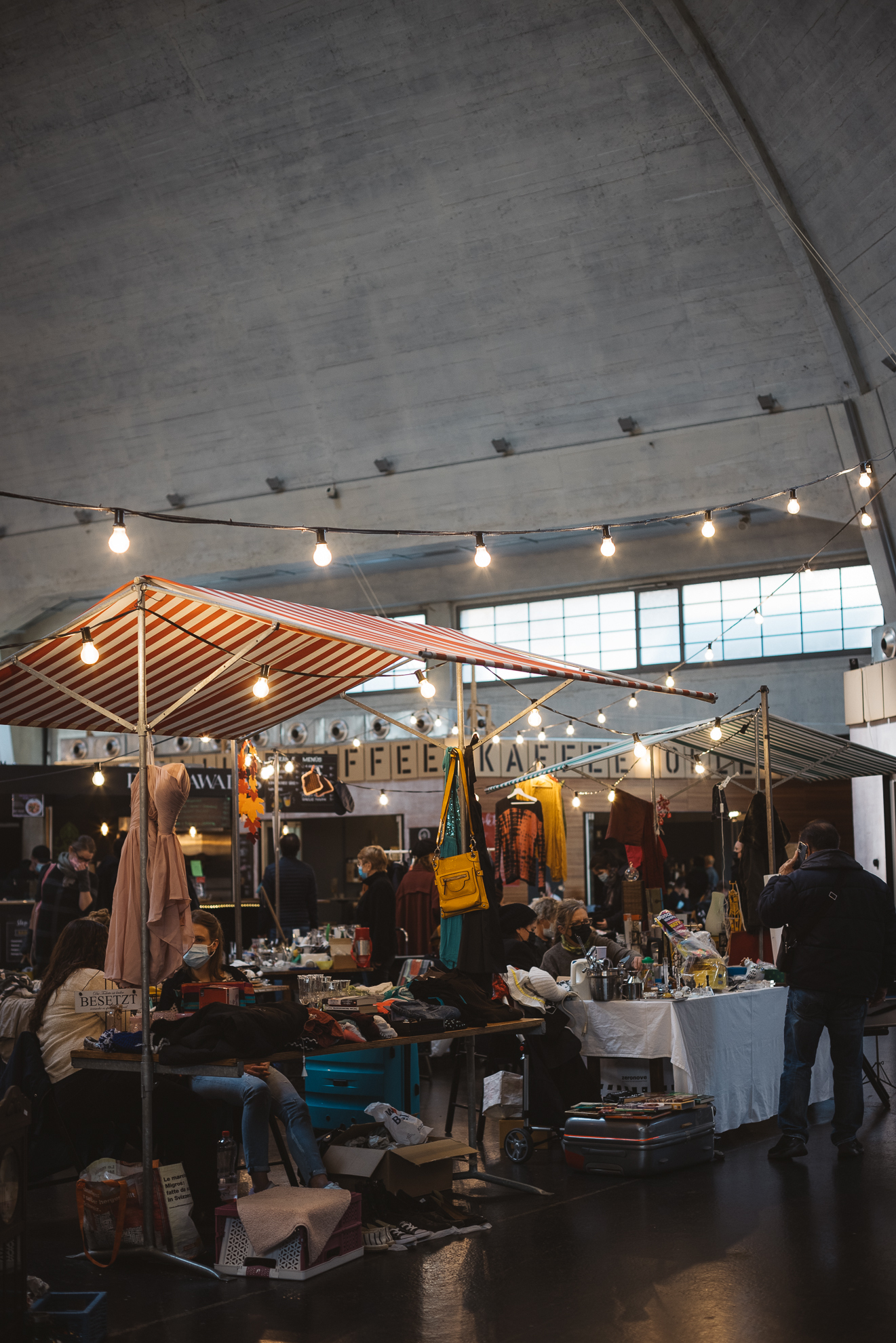 Verkaufsstände und Menschen im Innern der Markthalle