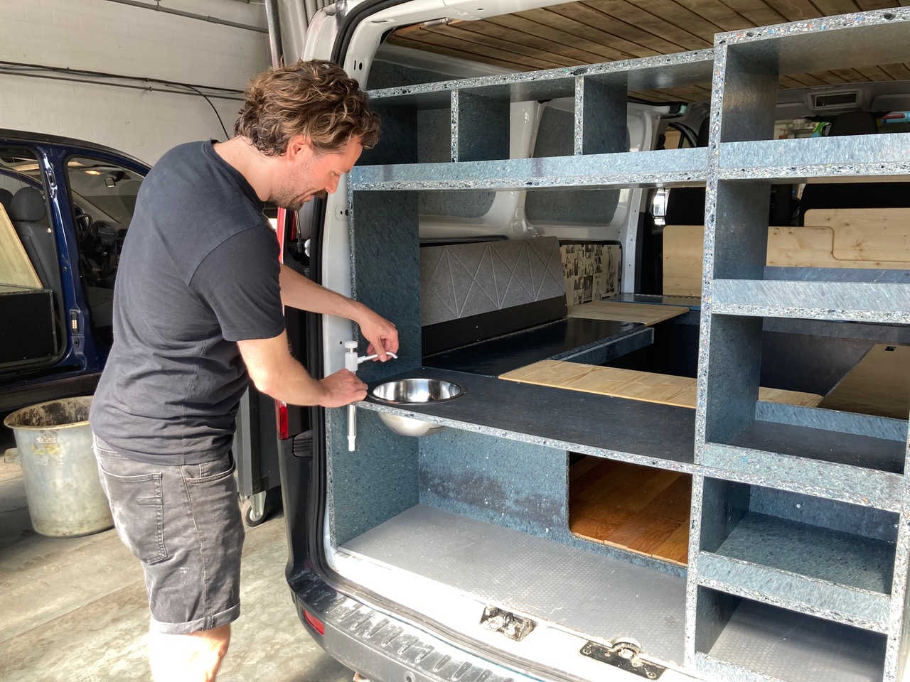 David Schweizer setzt das Waschbecken in den Camper ein.