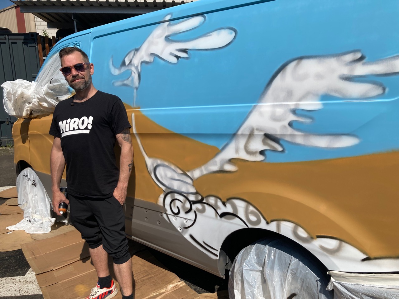 Sprayer Niro Dubs steht vor dem Camper, an dem er gerade arbeitet.