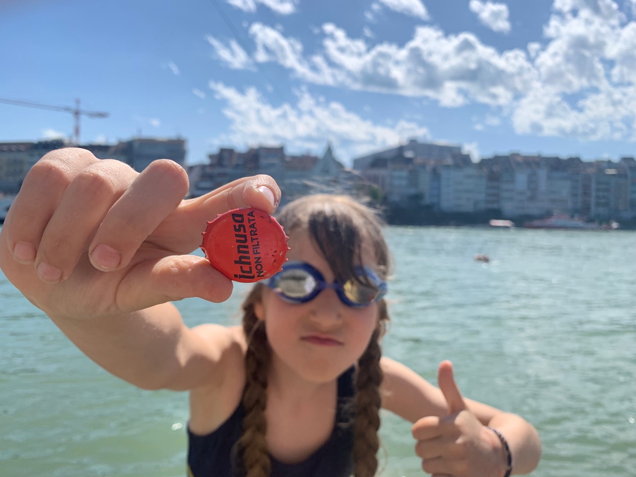Lili von Junioratelier hält gefundenen Abfall in die Kamera