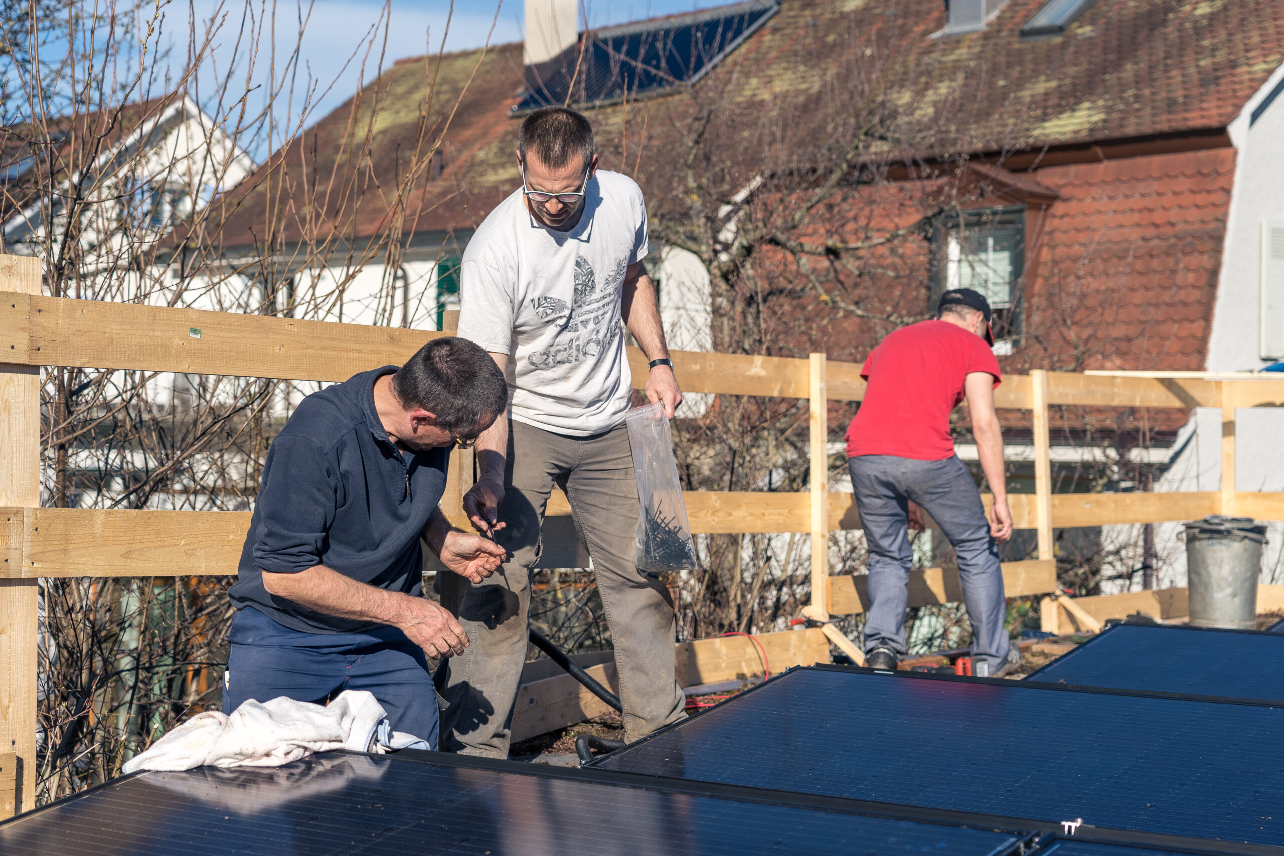 Gruppe auf einem Flachdach, bei der Montage einer Solaranlage