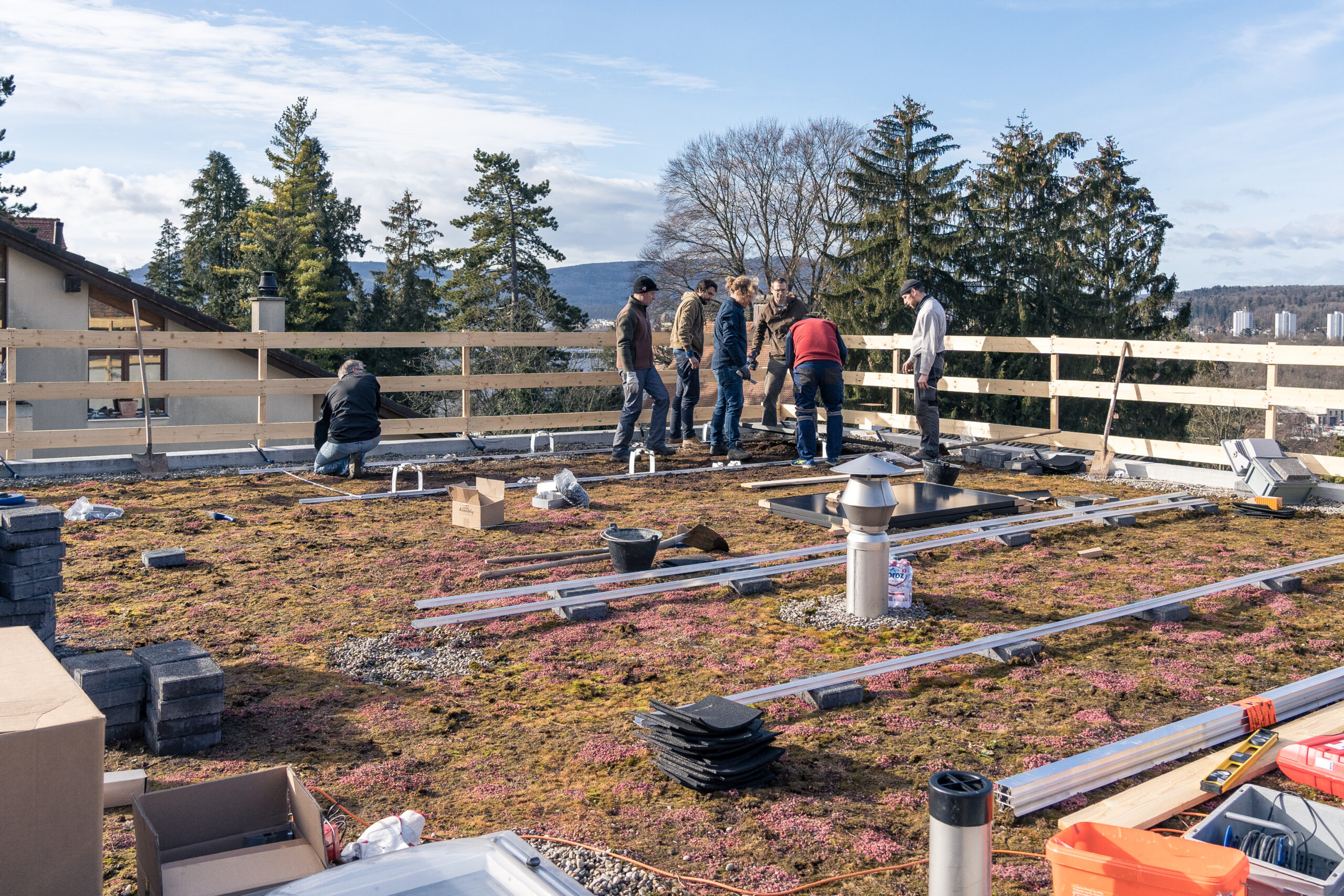 Gruppe auf einem Flachdach, bei der Montage einer Solaranlage