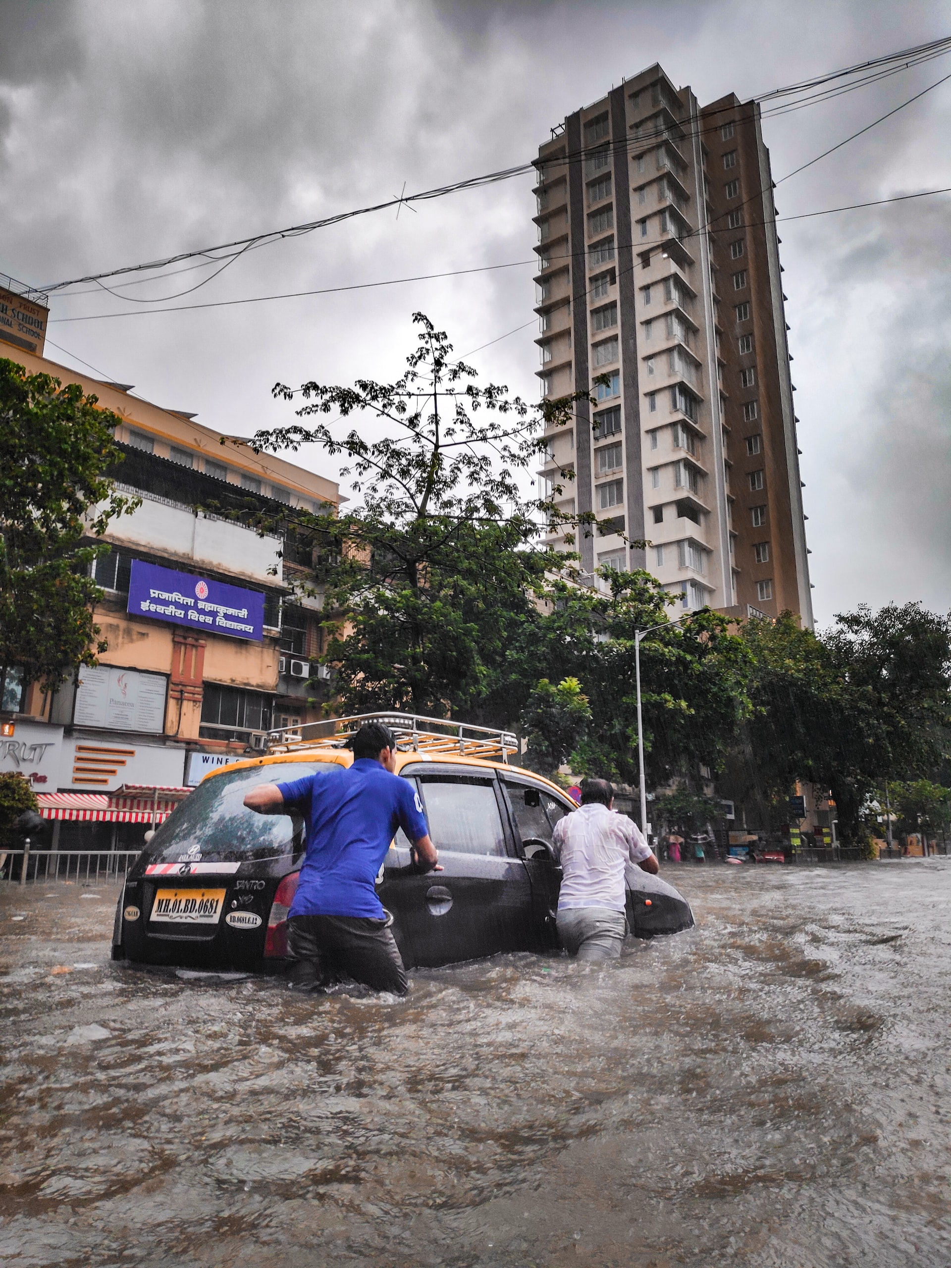 Menschen und Autos in einer überfluteten Strasse