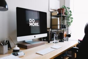 Bild von einem Schreibtisch, auf dem Computerbildschirm steht "Do More"