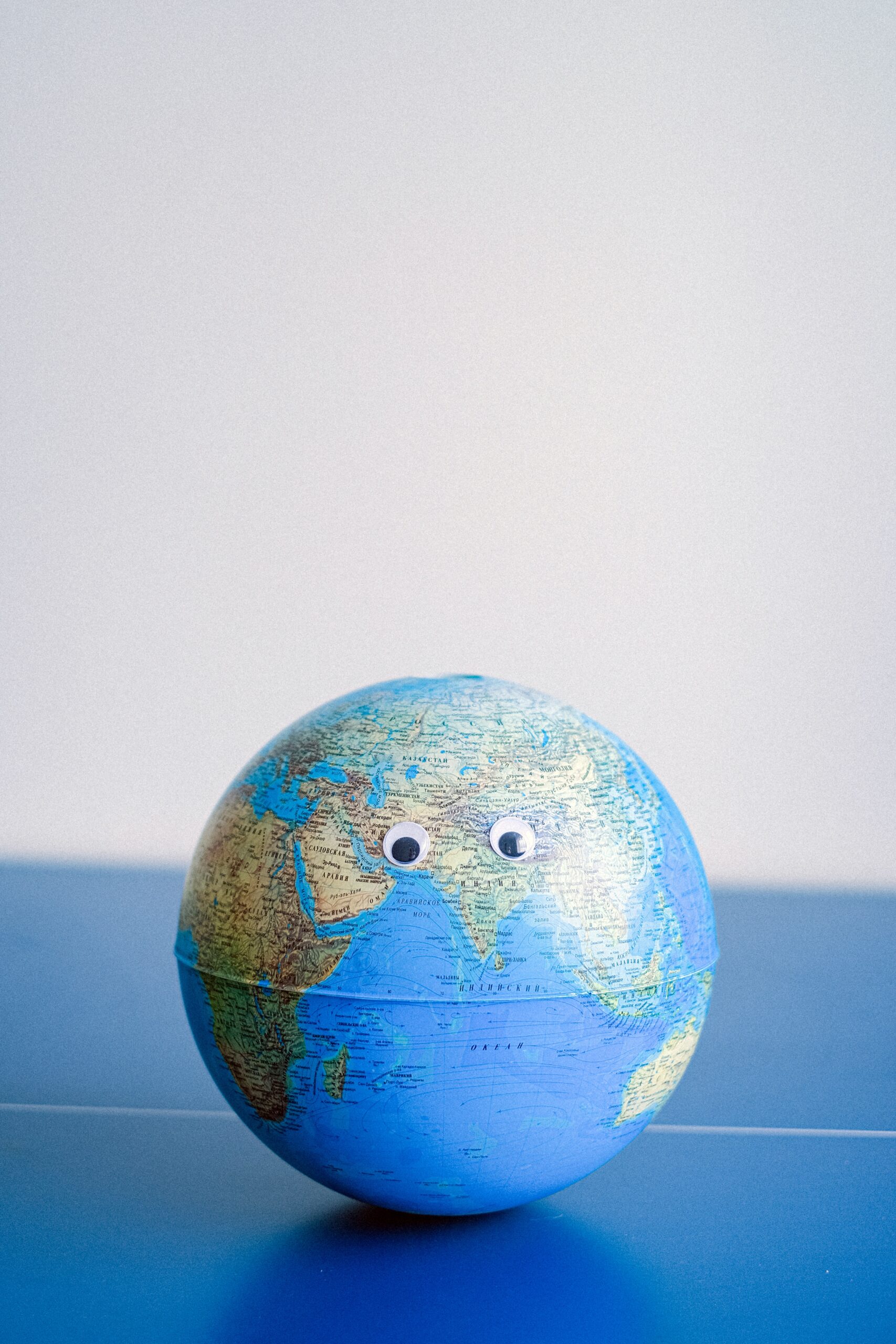 Bild eines Globus, dem Augen aufgeklebt sind, so dass er aussieht wie ein Gesicht.