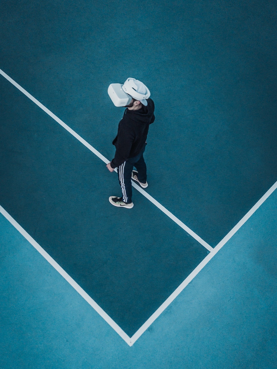 Person mit Virtual Reality Brille auf einem Tennisplatz.