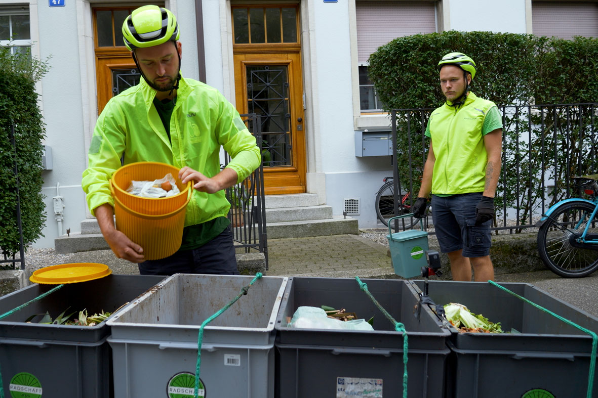 Florian Omlin und Olek leeren den Kompost in die Kisten auf dem Cargobike