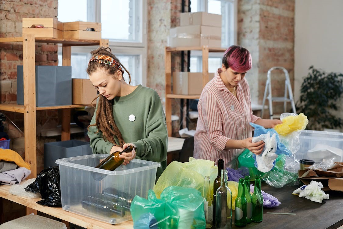 Zwei Frauen recyceln verschiedene Materialien