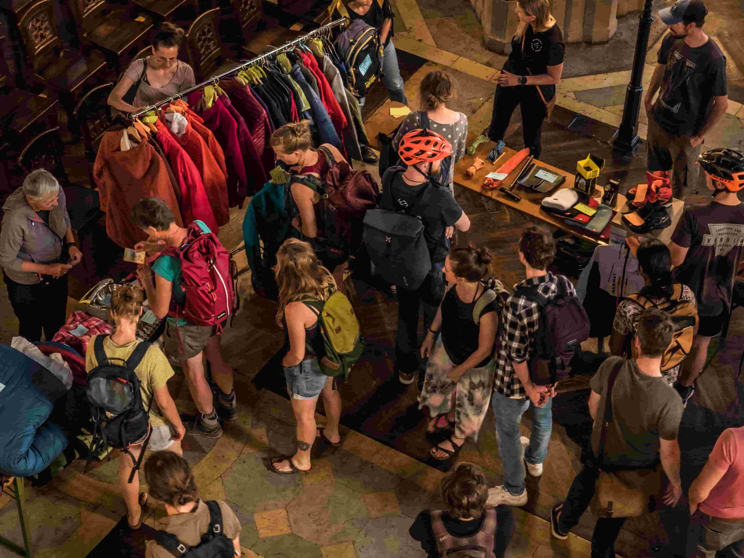 Blick von oben auf Menschen und Flohmarktstände mit Alpinsport-Artikeln