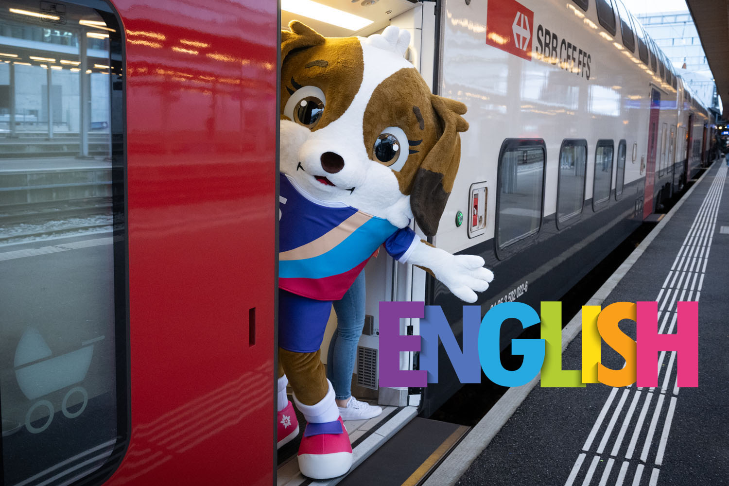 Maskottchen der Women's Euro steigt in den Zug. Schrift "English"
