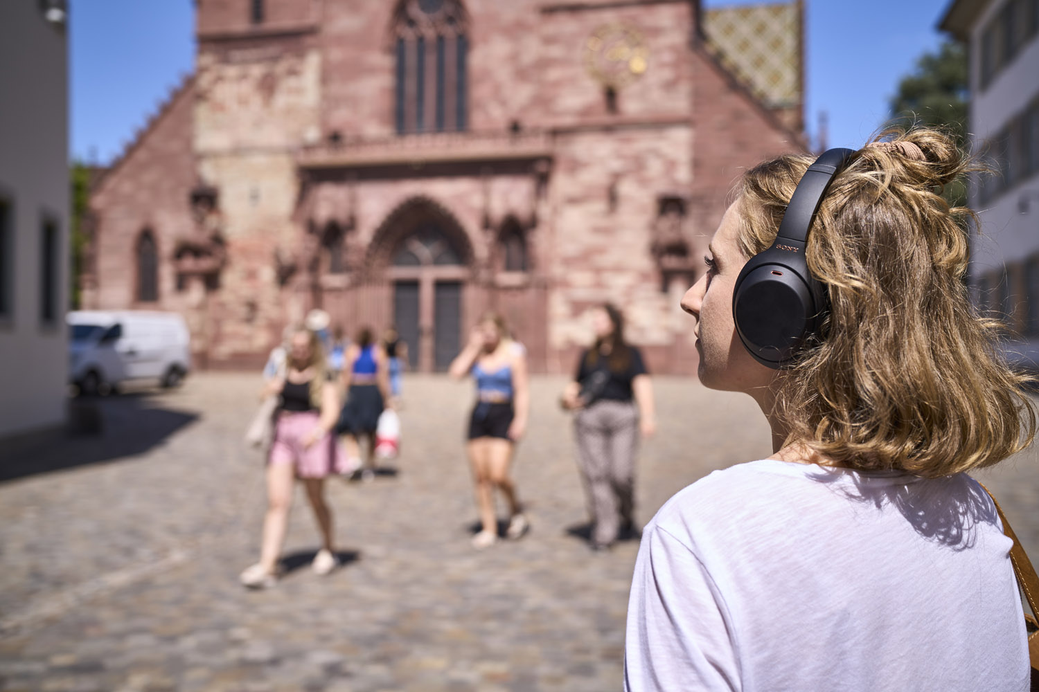 Eine Frau mit Kopfhörern auf dem Münsterplatz.