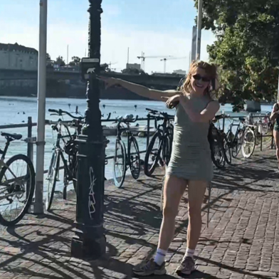 Sophie lächelt in die Kamera. Im Hintergrund ist die Johanniterbrücke und der Rhein.
