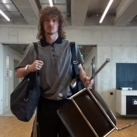Gian mit einem Stuhl und einer Tasche