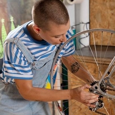 Eine Person repariert das Rad eines Velos.