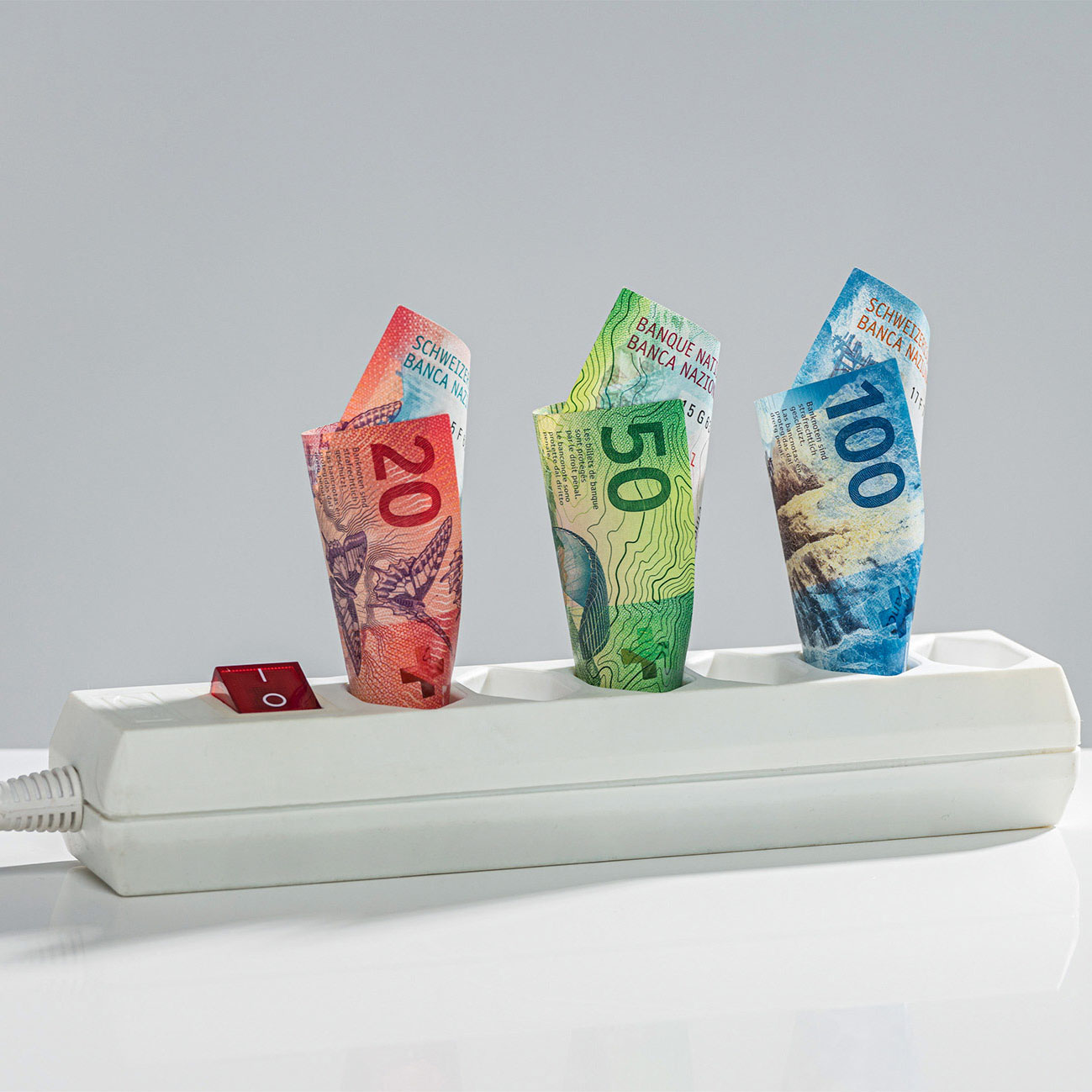 Stromsparleiste mit Geldscheinen