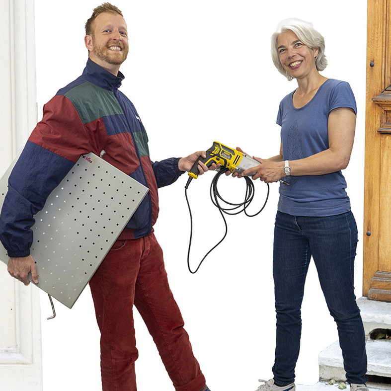 zwei Personen teilen eine Bohrmaschine