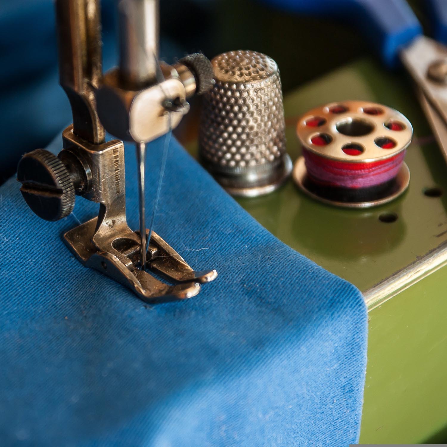 grüne Nähmaschine mit blauem Stoff