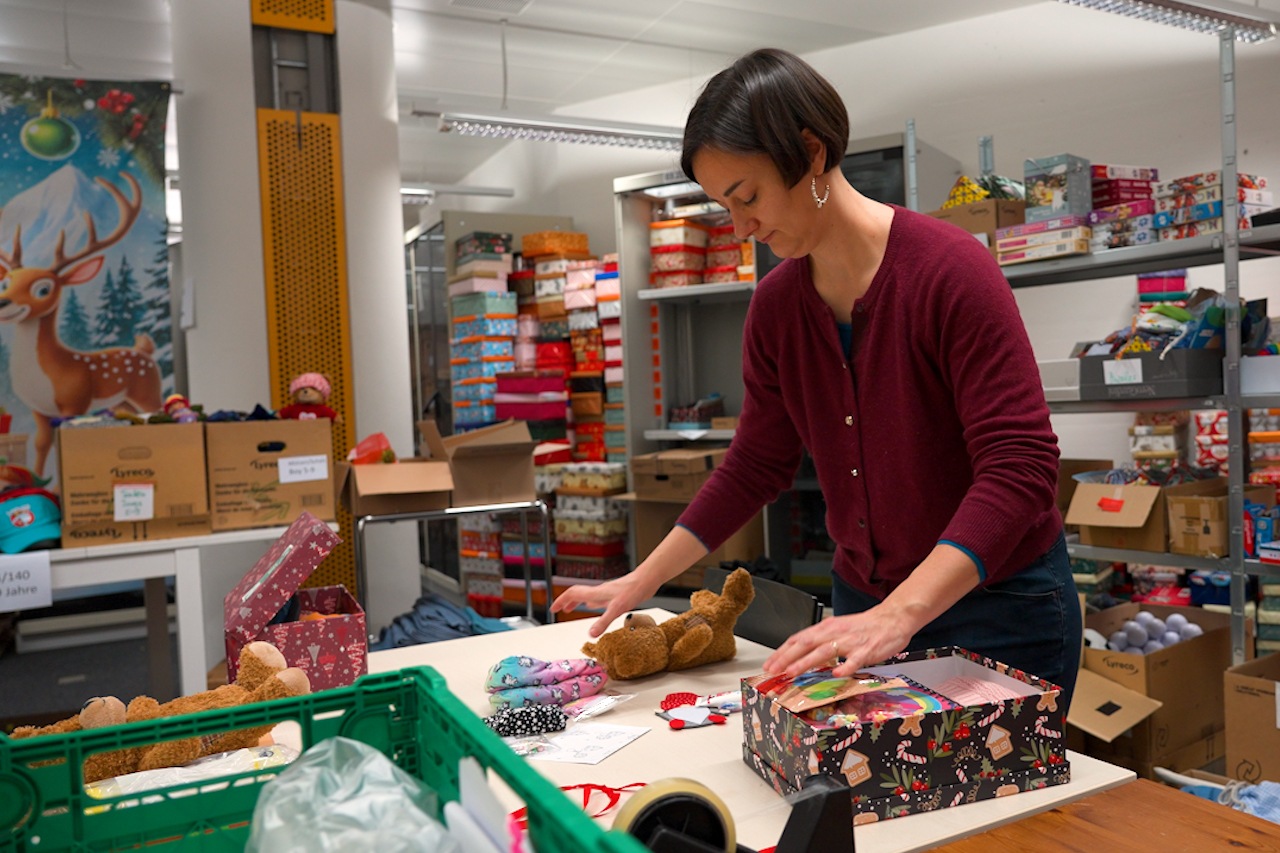 Eine Person verpackt einen Schuhkarton.