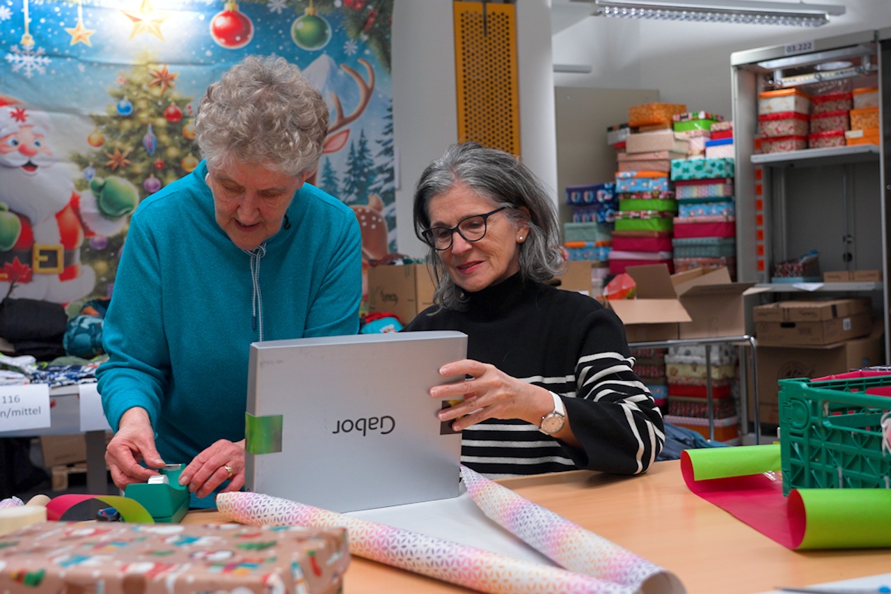 Zwei Frauen inspizieren einen Schuhkarton.