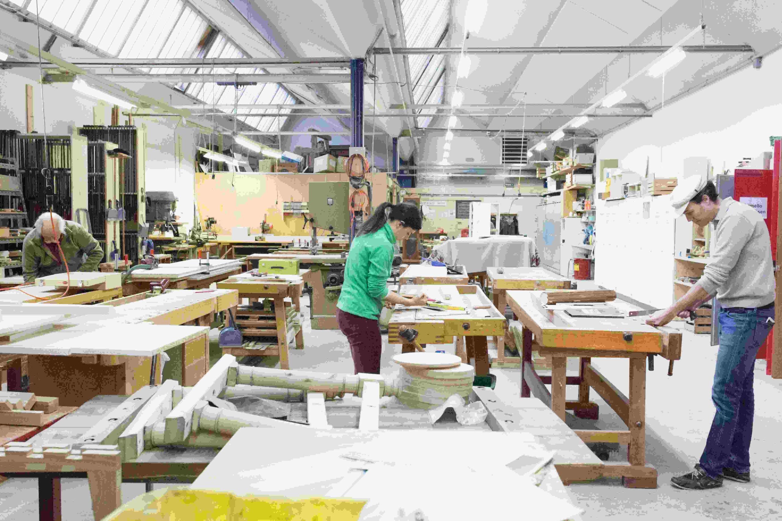 Eine offene Werkstatt mit drei Personen.
