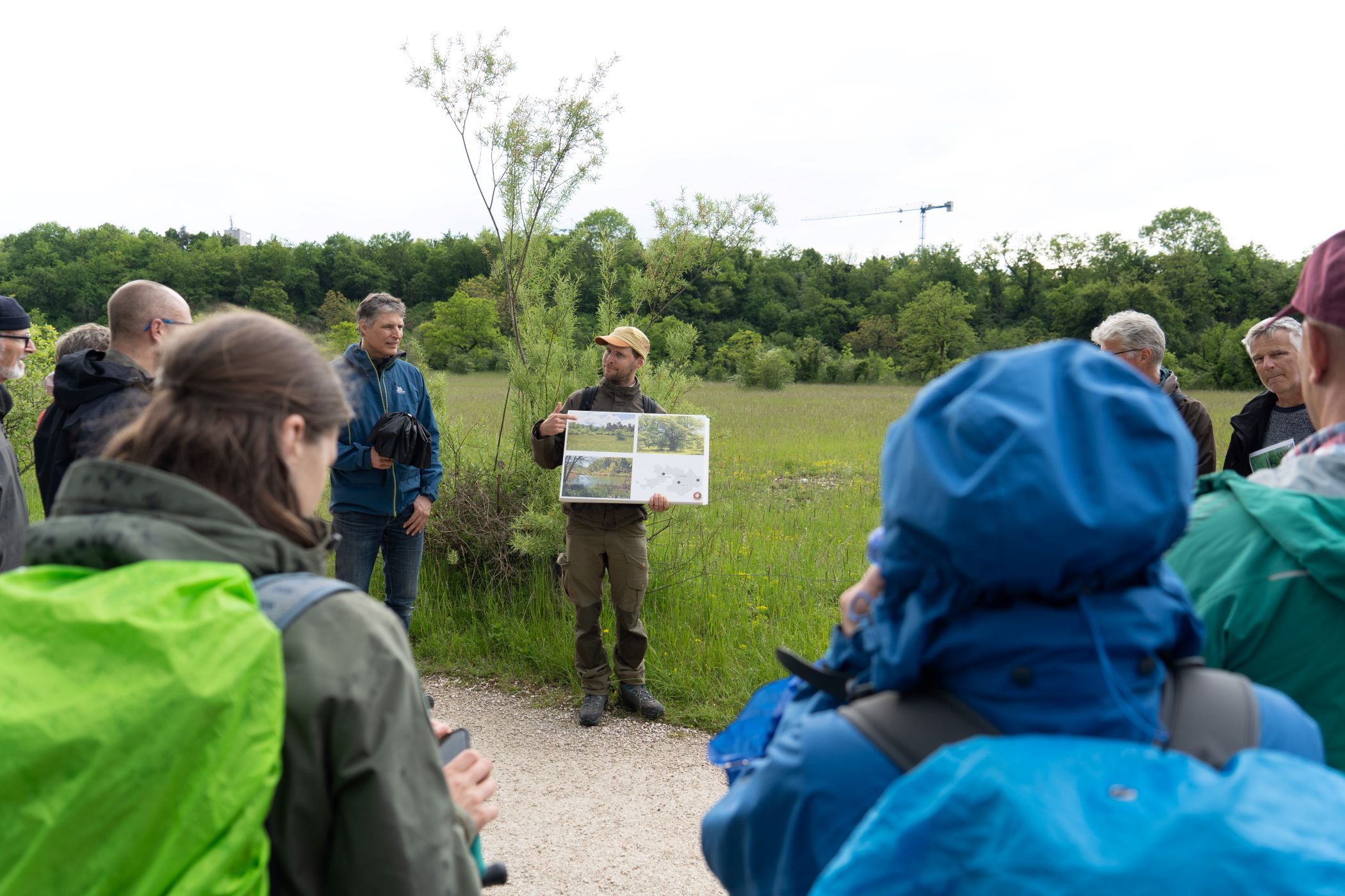 Menschengruppe in der Reinacher Heide. Ein Führer zeigt ein Plakat.