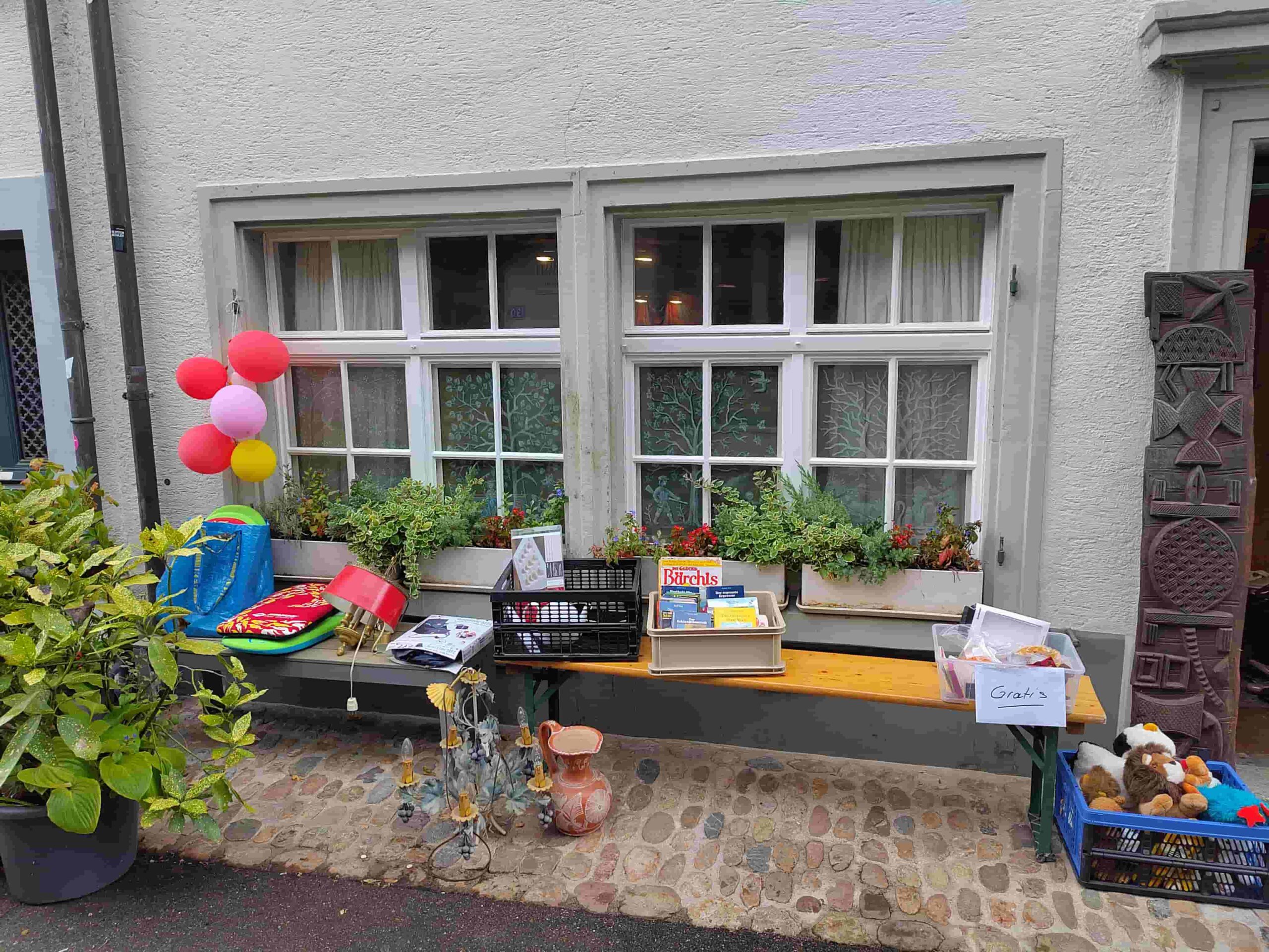 Stand vor einem Haus mit Flohmarktwaren