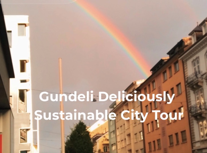 Stadthäuser mit Regenbogen im Hintergrund und der Schrift: Gundeli Deliciously Sustainable City Tour