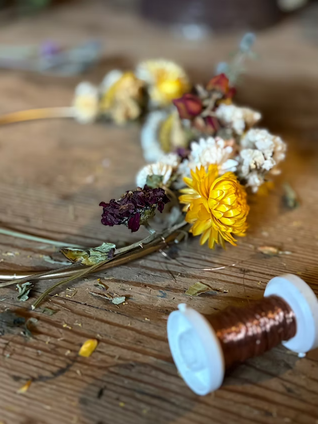 Trockenblumen und Bindefaden auf einem Tisch